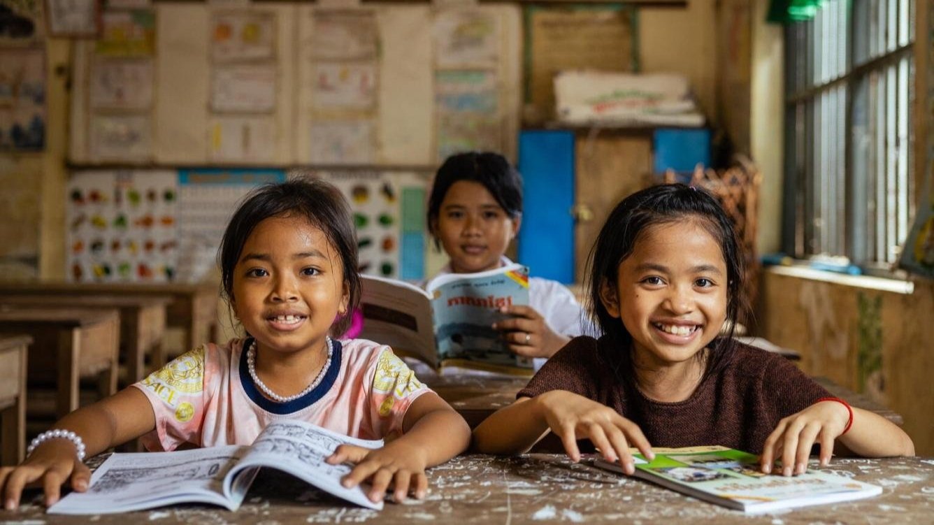 Girls reading together in a classroom